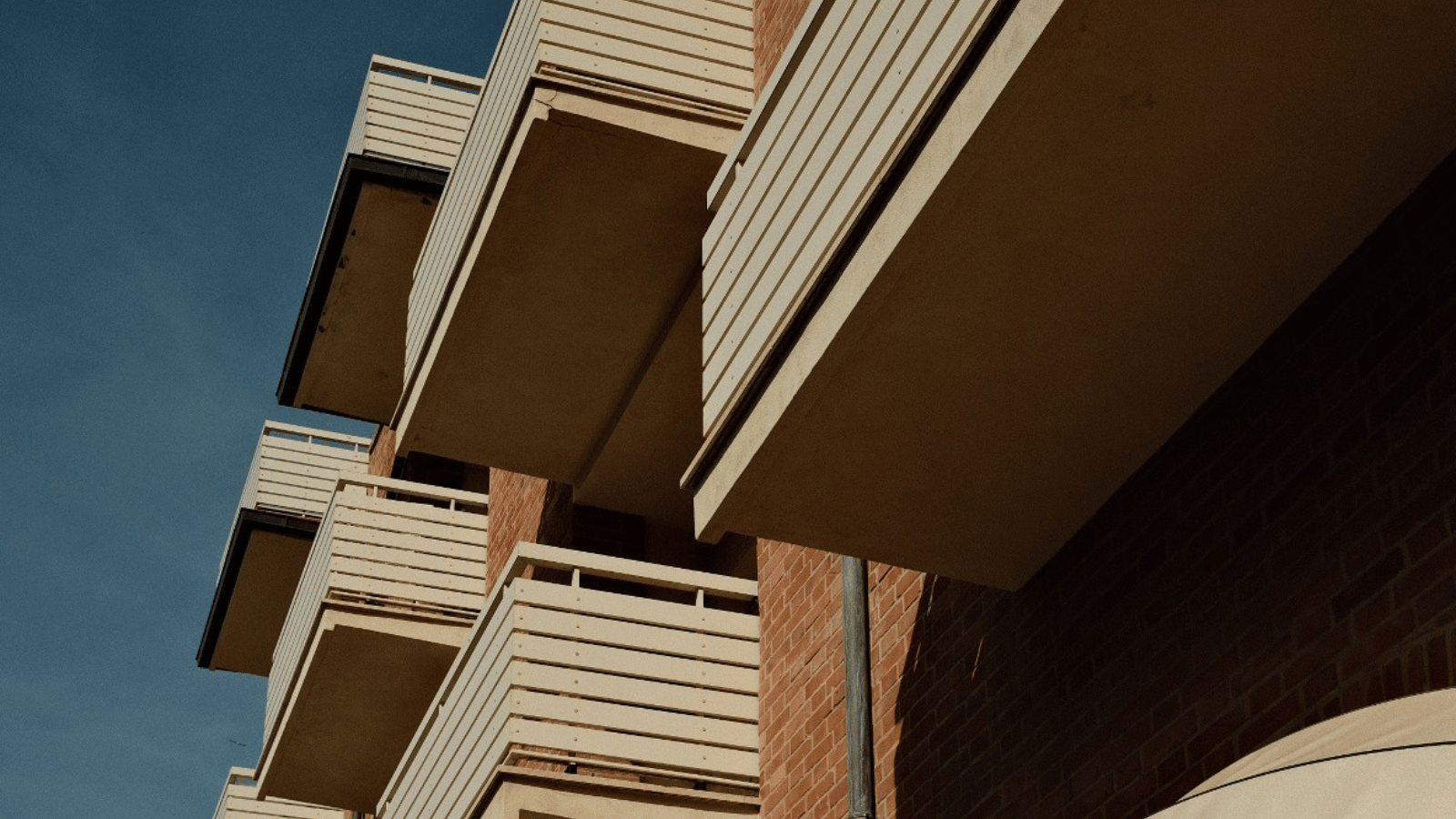 Moderne italienische Hausfassade mit Balkonen, Sinnbild für die Bedeutung von Eigentum in Italien als Schritt in die Selbständigkeit